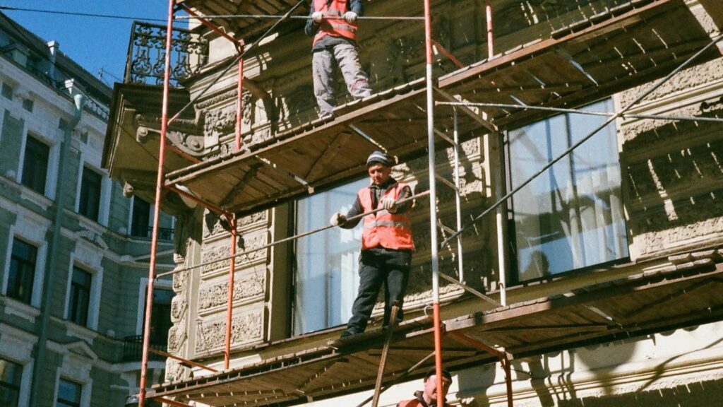 Men on brown scaffolding
